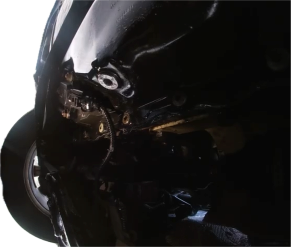 A close-up detailed view of a motorcycle engine and front components against a dark background, showcasing mechanical craftsmanship and engineering.