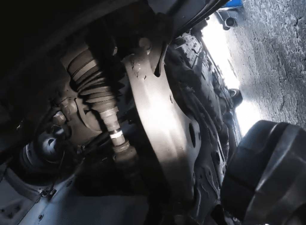 A close-up view of an automotive engine block and brake components in a workshop setting.