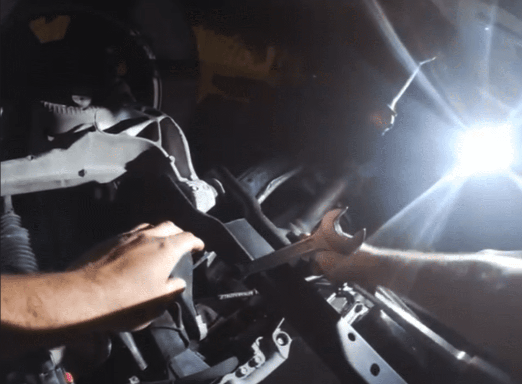 A close-up view of hands operating professional camera and lighting equipment in a film or television production workshop.