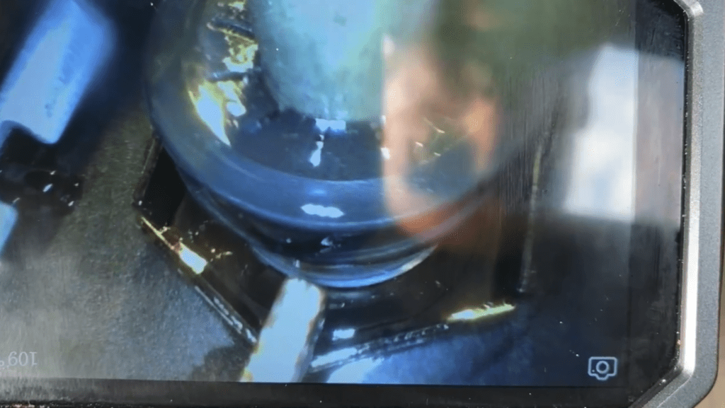 A close-up view of a blue pot or cooking vessel on a gas burner with flame visible inside.