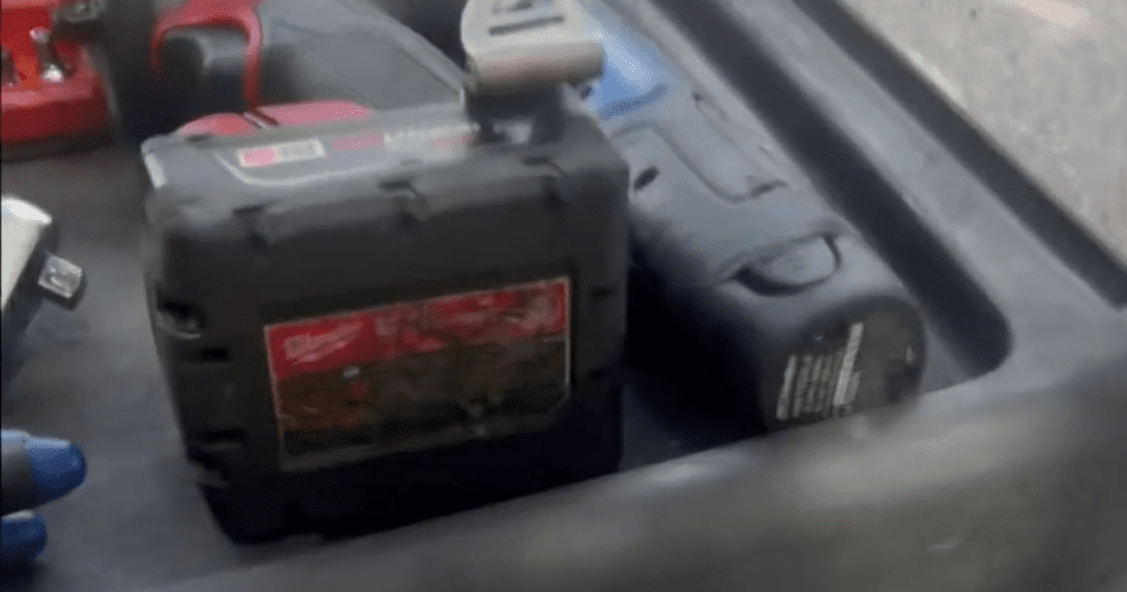 A professional video camera is mounted or placed in a vehicle interior, showing its display screen and control equipment.