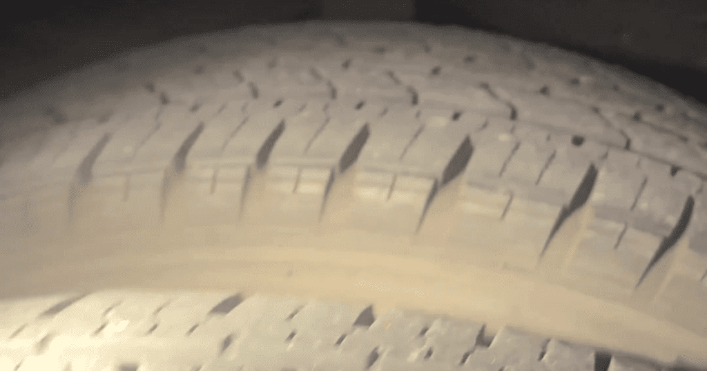 A close-up photograph of a vehicle tire's tread pattern showing detailed grooves and rubber texture.