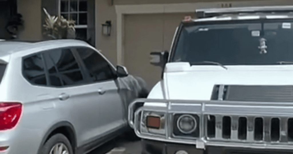 Two white vehicles parked on a residential driveway in front of a garage during daytime.